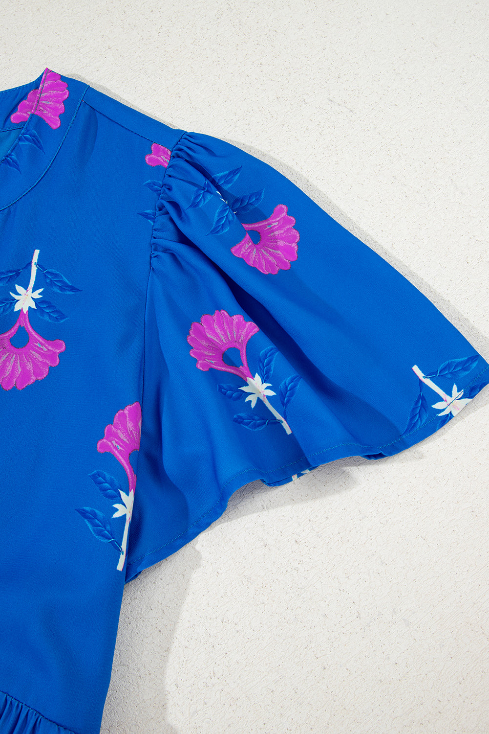 Blue dress with pink floral patterns on a white background