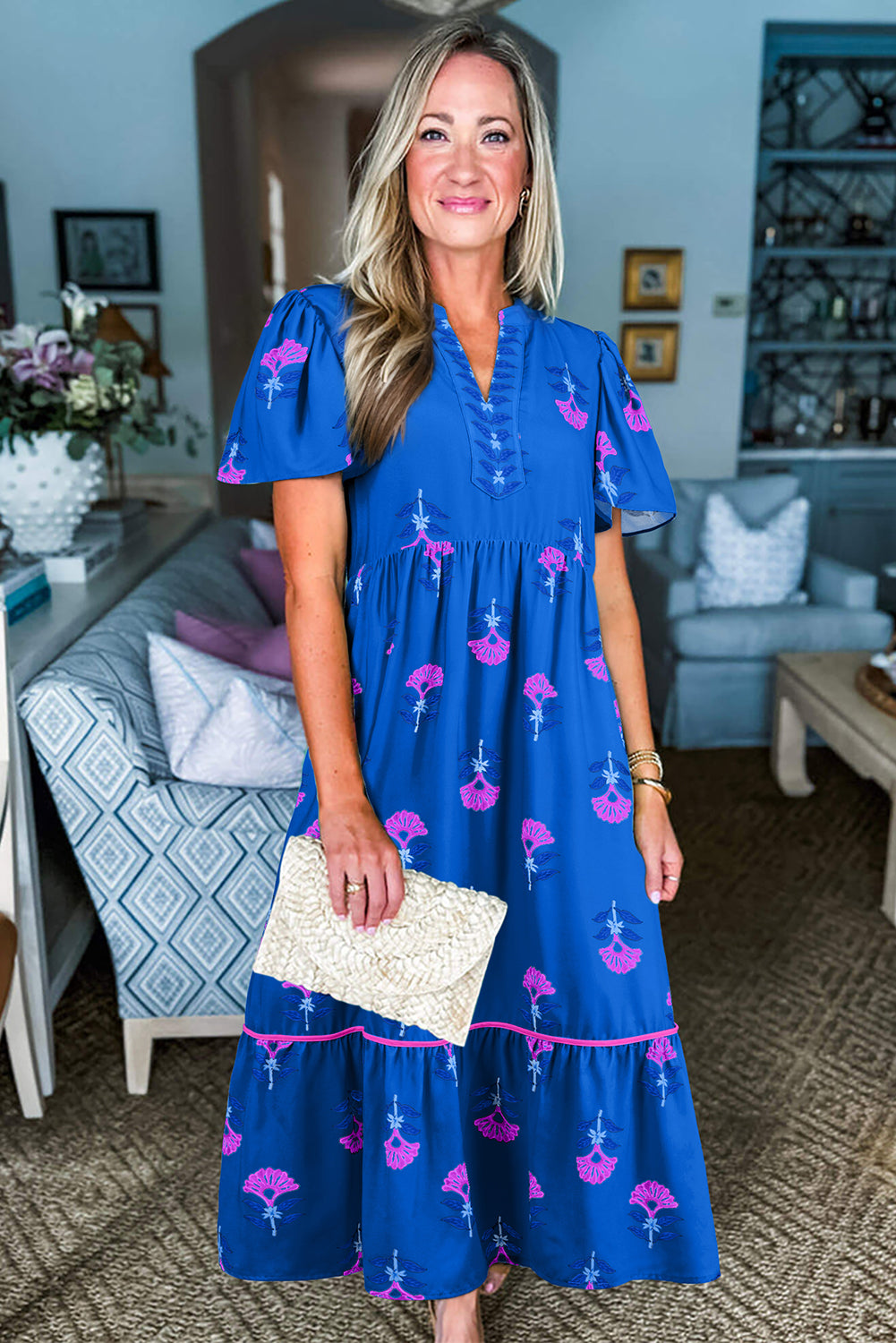 Woman in a blue dress with pink flamingo pattern in a living room setting