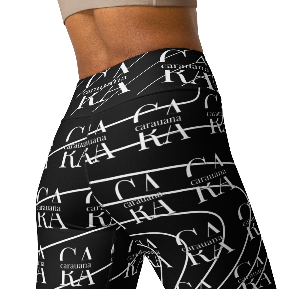 Black leggings with white branding pattern worn by a person on a white background