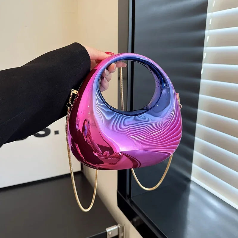 Person holding a pink and purple reflective handbag in front of a mirror.