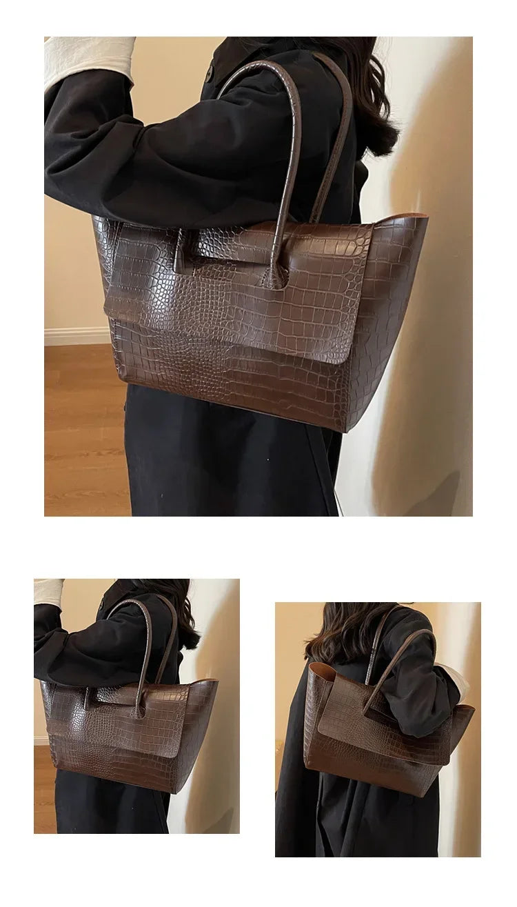 Brown Carauana Crocodile handbag held by a person against a plain background