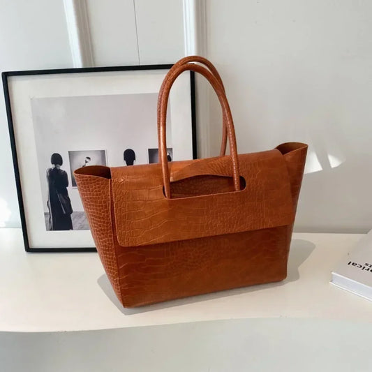 Carauana Crocodile Leather Handbag on a white surface with a framed picture in the background