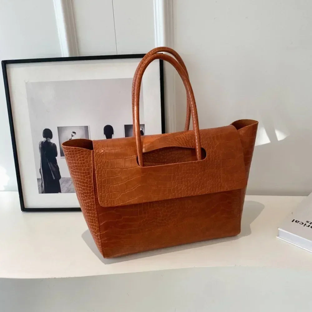 Carauana Crocodile Leather Handbag on a white surface with a framed picture in the background