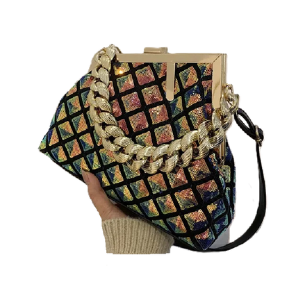 Multicolored patterned handbag with gold chain strap held by a hand on a white background