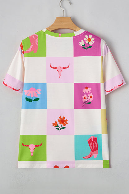 Colorful checkered tee with floral and cowgirl boot patterns on a hanger against a gray background