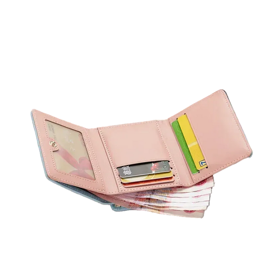 Pink wallet with cards on a magazine with sunglasses and floral design in the background