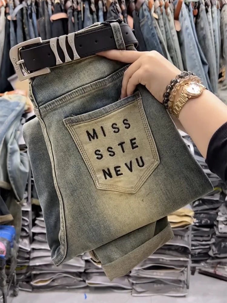 pair of jeans with 'MISS SSTE NEVU' patch in a clothing store.